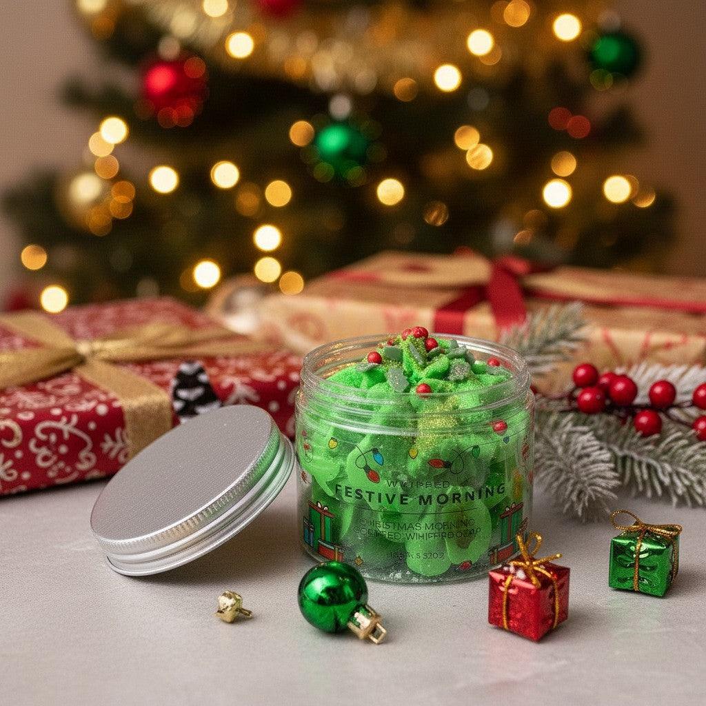 Absolute Whifs Festive Morning whipped soap in a clear jar with a silver lid, set against a blurred Christmas tree.