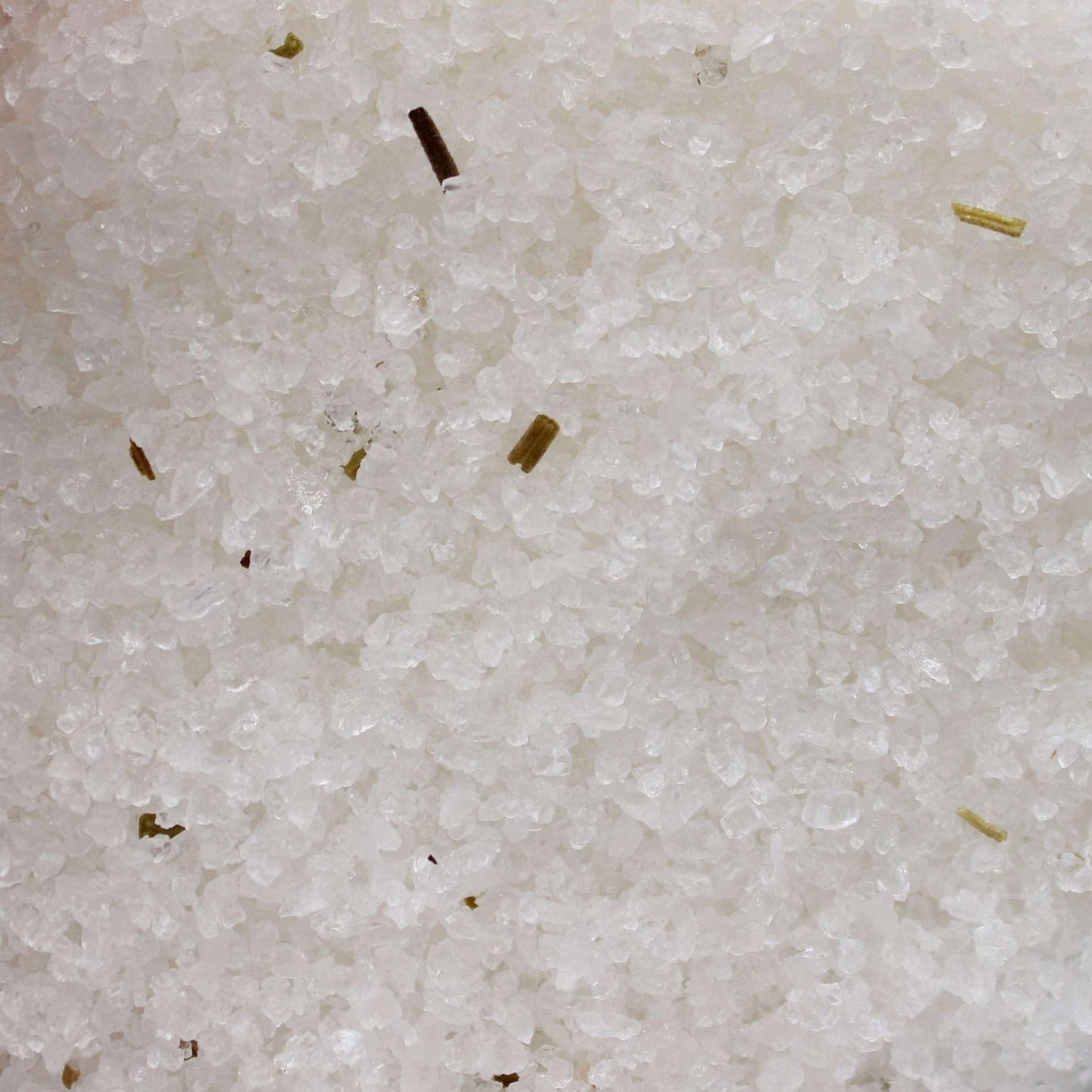 Close-up of Himalayan Bath Salt Blend with rosemary and clary sage essential oils and dry herbs for aromatherapy bath experience