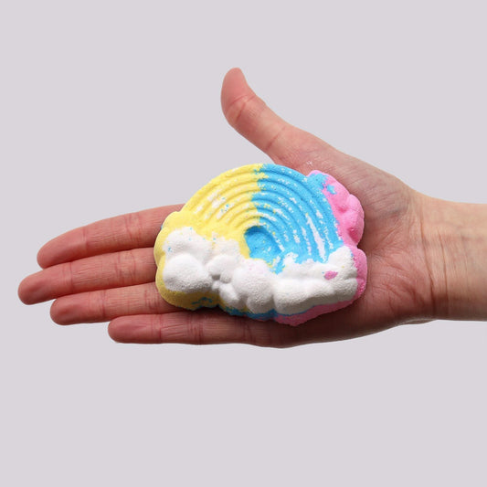 Cloud Bath bomb 95g in vibrant rainbow colours held in hand, shaped like a cloud with foaming texture