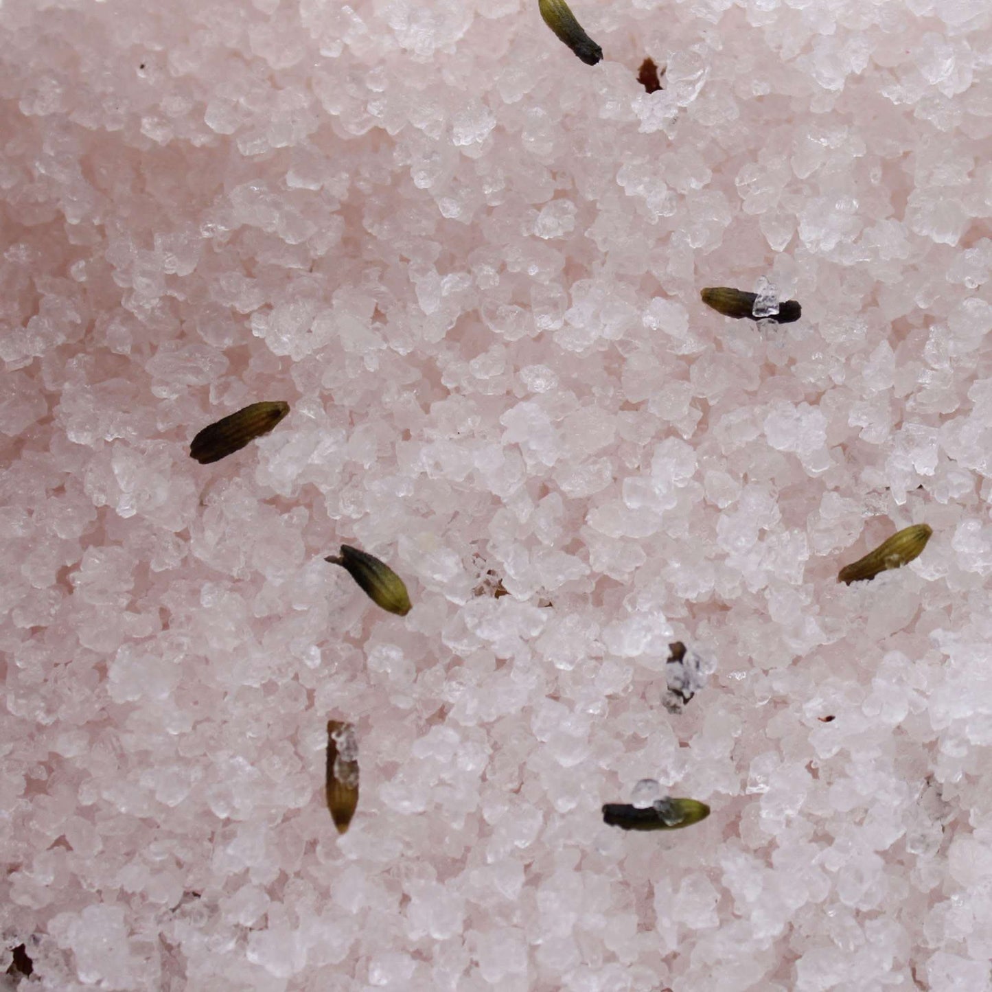 Close-up of pink Himalayan bath salt crystals infused with lavender seeds