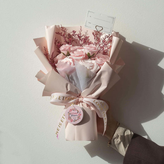 Large pink roses bouquet wrapped in pale pink paper with satin ribbon and gift card