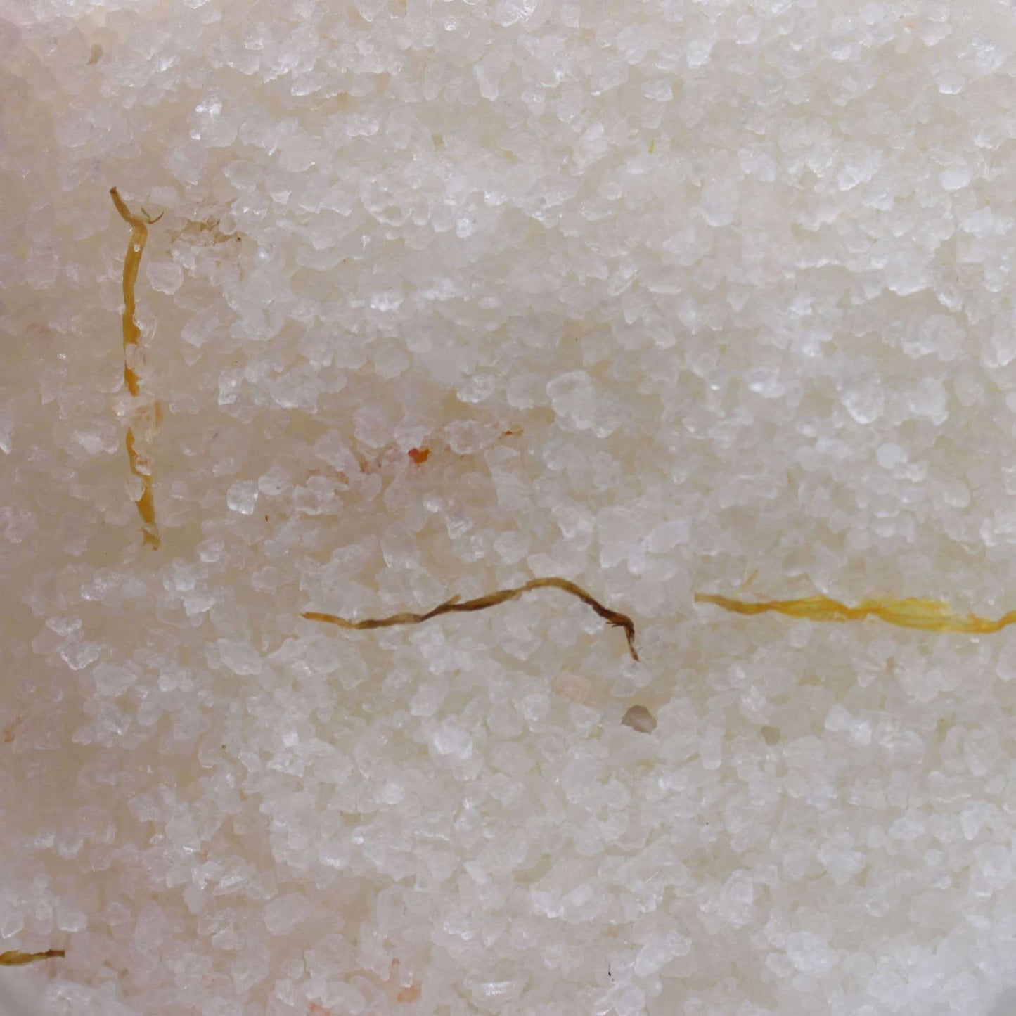 Close-up of mineral-rich Himalayan bath salt with dried marigold flowers infused with essential oils