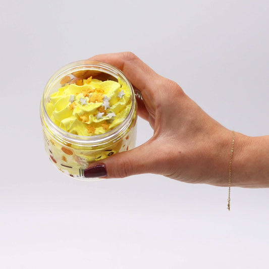 Cosy Winter Nights whipped soap 120g with yellow swirl, shimmering glitter, and sugar stars in jar held by hand