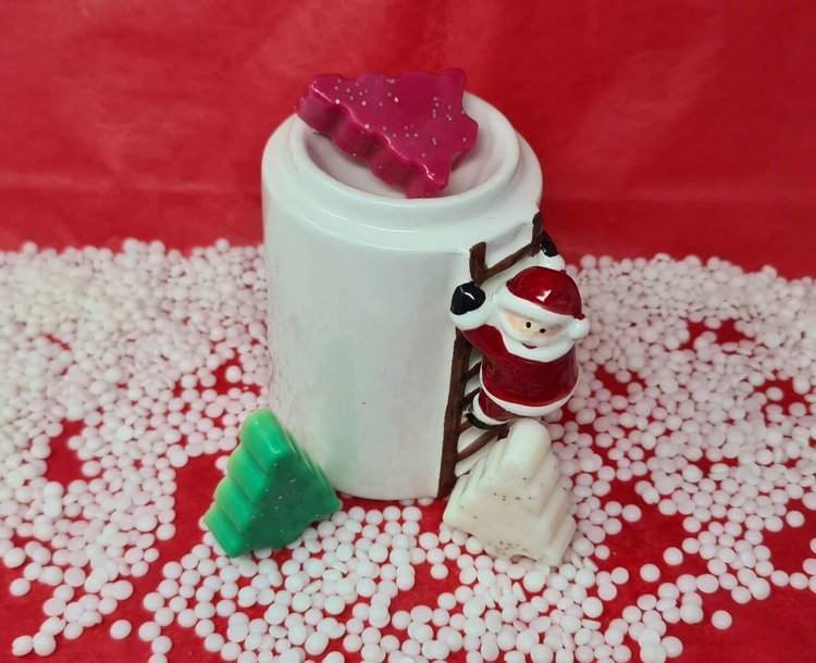 Christmas tree scented wax melts with Santa-themed holder and festive colors.