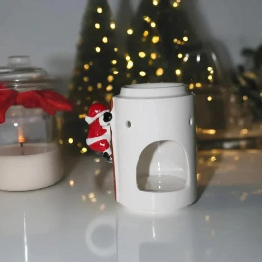 Climbing Santa Wax Burner in glossy white ceramic, with a red-and-white Santa figure peeking around the side