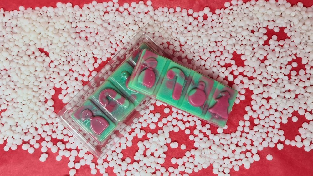 Cranberry Peppermint wax melt snap bar on scattered white pellets.