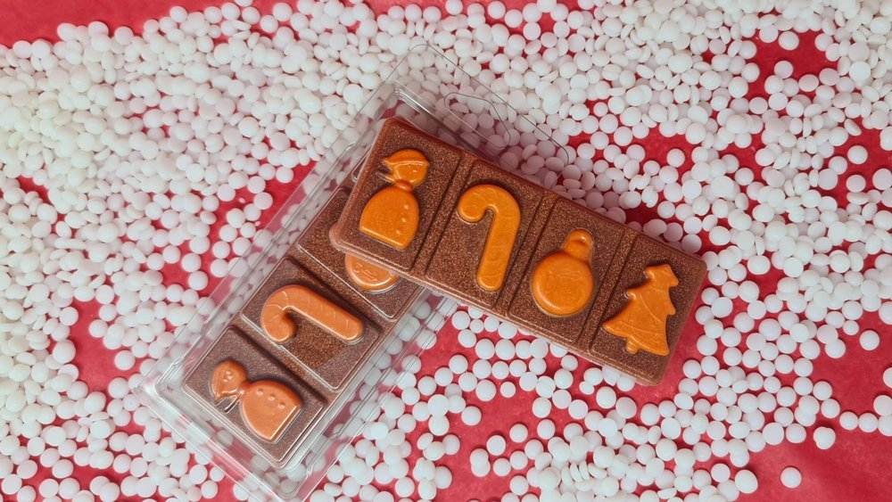 Gingerbread wax melt snap bars with festive shapes on red and white background.