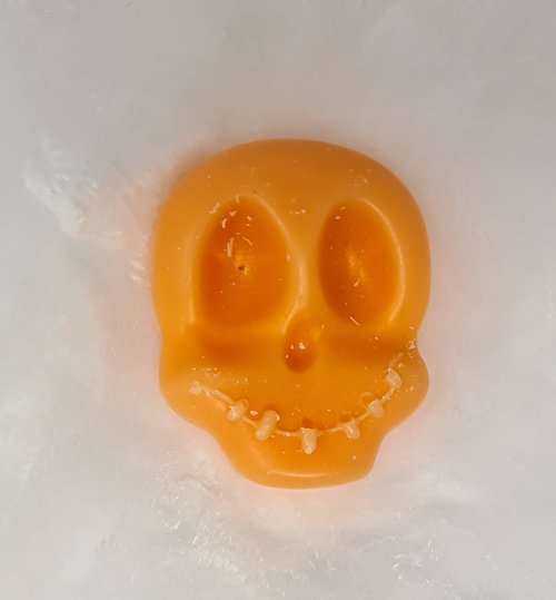 Pumpkin skull-shaped soy wax melt with pumpkin spice scent.