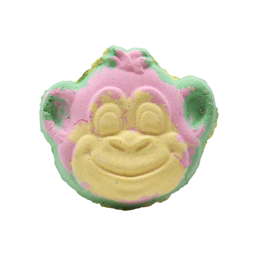 Monkey Bath bomb shaped like a smiling monkey face in pastel pink, yellow, and green colors with a textured surface