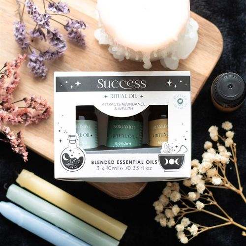 Set of 3 Success Ritual Blended Essential Oils with Frankincense, Bergamot, and Peppermint bottles on display.