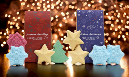 Christmas bath bombs gift packs with sparkling lights in the background