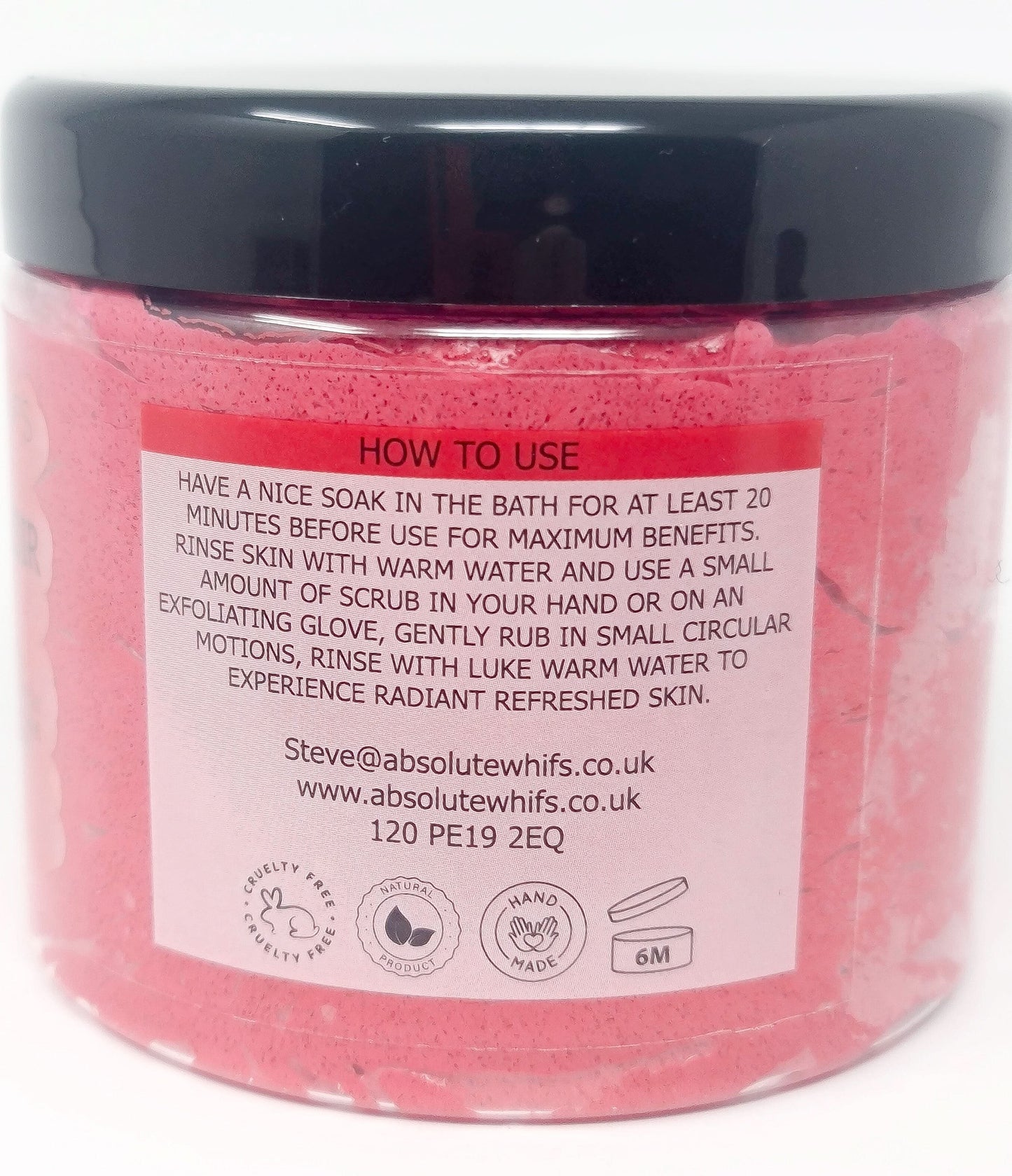 Pomegranate Noir Sugar Body Scrub in clear jar with black lid showing usage instructions and pink texture