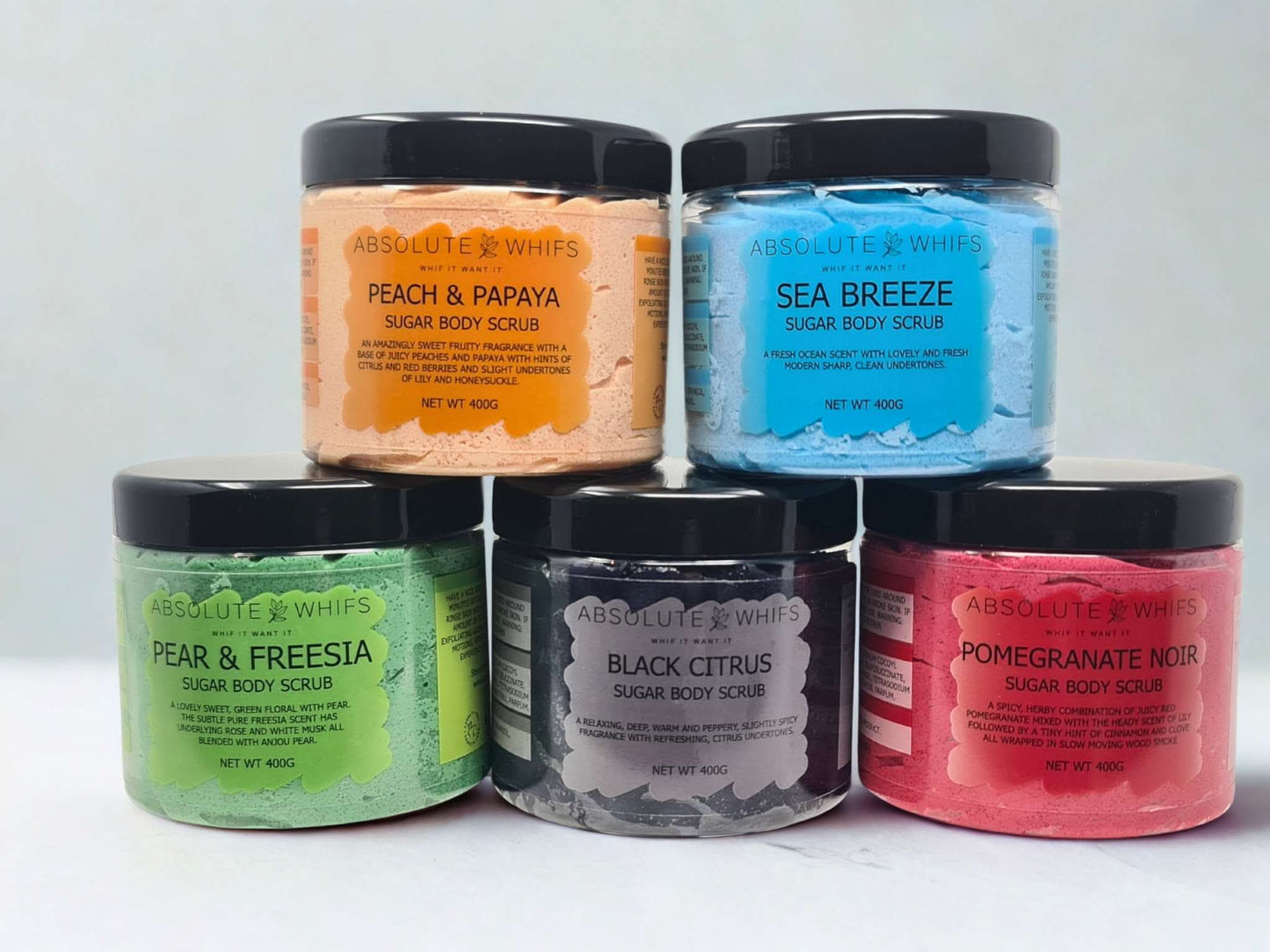 Five jars of Absolute Whifs sugar body scrubs including Black Citrus Sugar Body Scrub in black jar with black lid