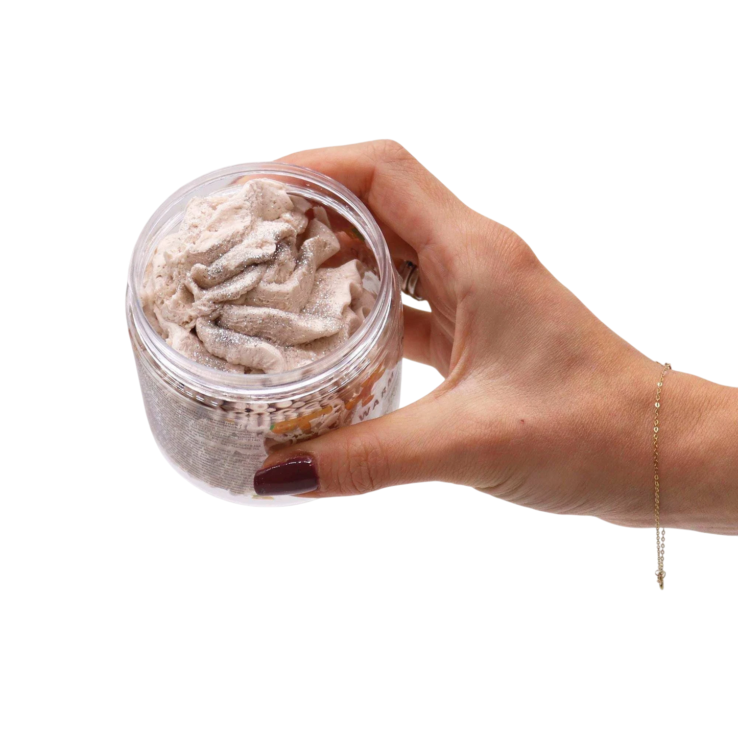 Absolute Whifs Warm Gingerbread whipped soap in a clear jar held by a hand, featuring a creamy, light brown texture.
