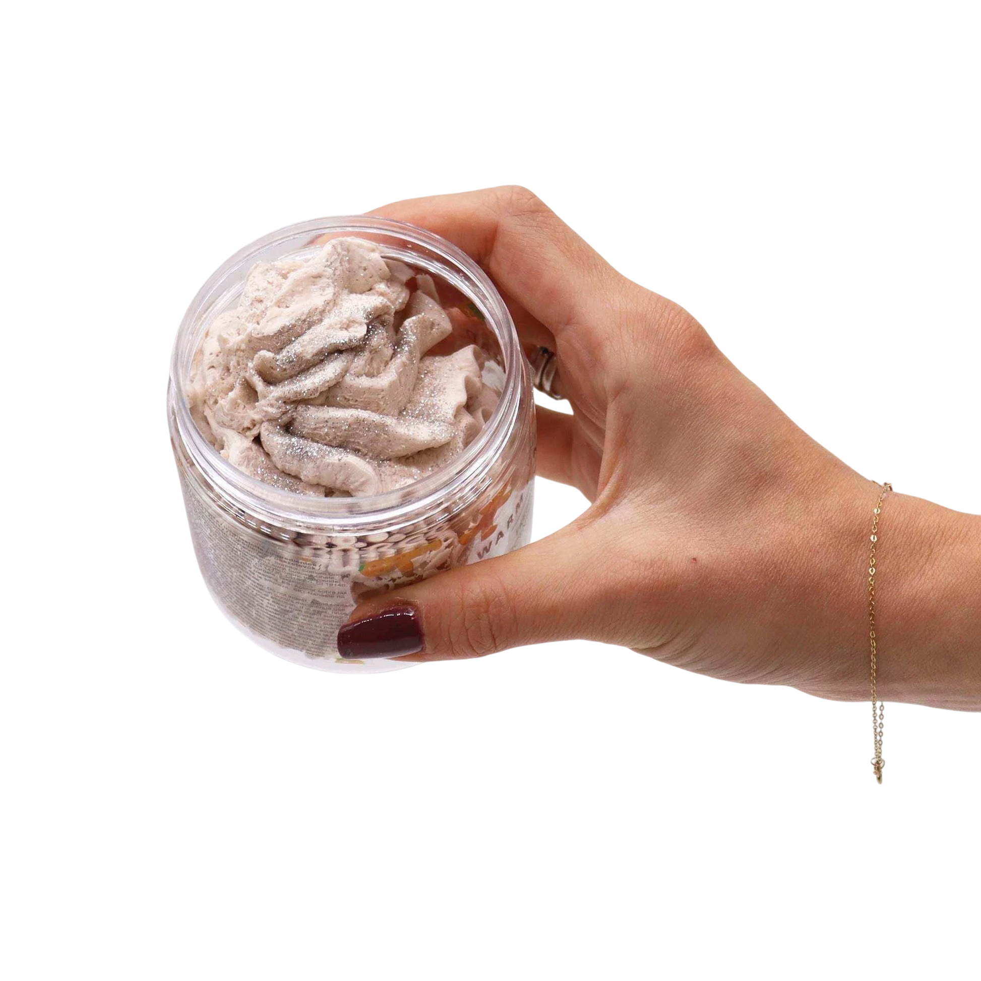 Absolute Whifs Warm Gingerbread whipped soap in a clear jar held by a hand, featuring a creamy, light brown texture.