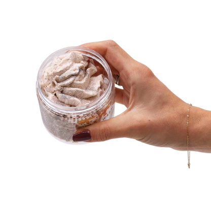 Absolute Whifs Warm Gingerbread whipped soap in a clear jar held by a hand, featuring a creamy, light brown texture.