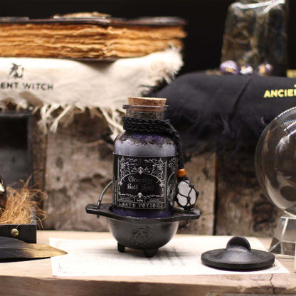 Ancient witch bath spell potion in glass bottle with cork and rock crystal amulet on black cord