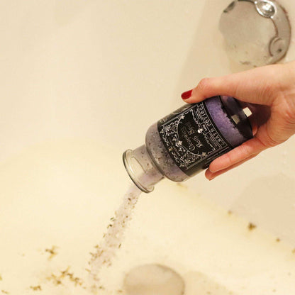 Ancient witch bath spell potion in glass bottle with cork and rock crystal amulet on black cord