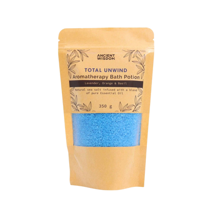 Aromatherapy Bath Potion - Total Unwind in kraft paper bag with blue bath salt grains visible, featuring lavender, orange, and basil essential oils