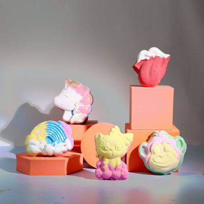 Colorful unicorn-shaped passion fruit scented bathbomb among other shaped bathbombs on pink platforms