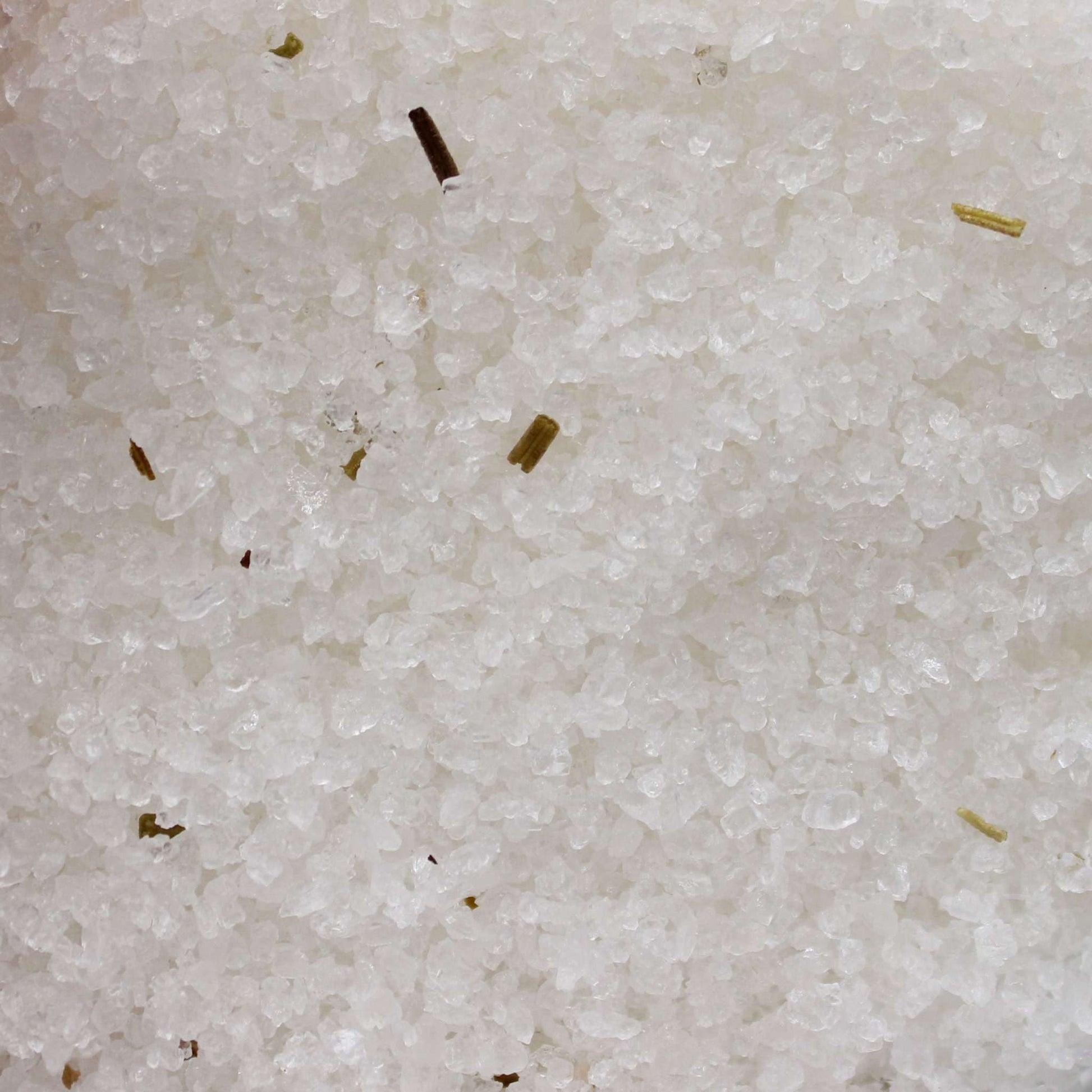 Close-up of Himalayan Bath Salt Blend with rosemary and clary sage essential oils and dry herbs for aromatherapy bath experience