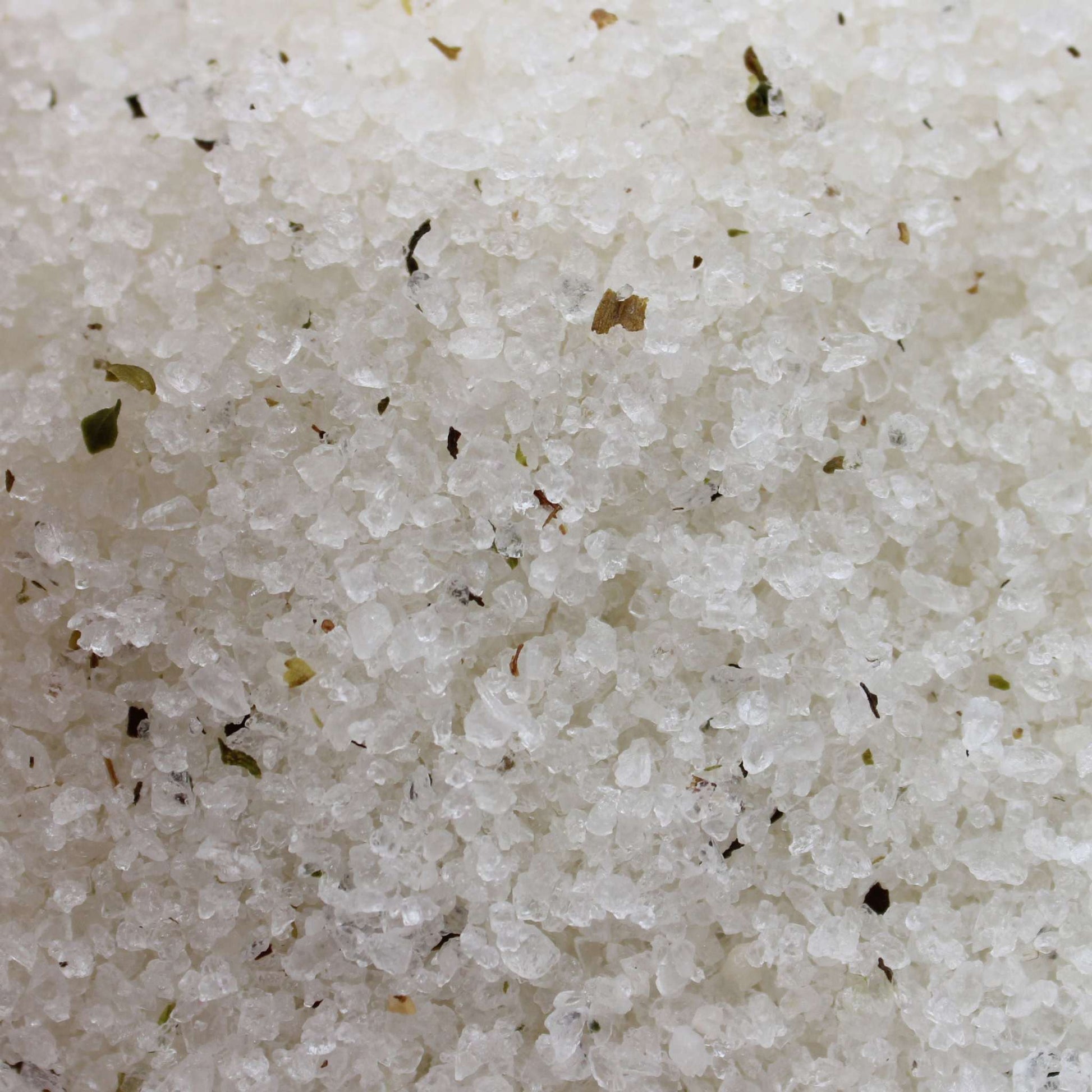 Close-up of detoxifying Himalayan bath salt blend with tea tree, lime, evening primrose oils and dry herbs