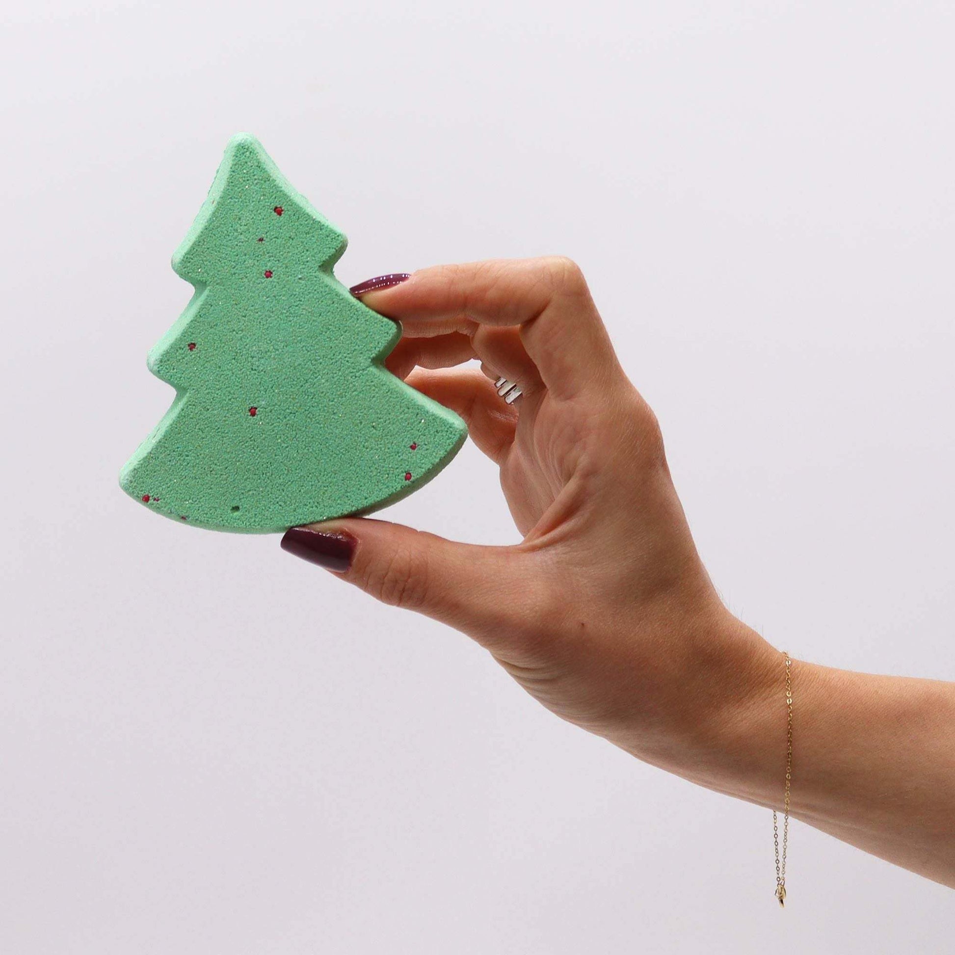 Hand holding green Christmas tree bath bomb from Silent Night Christmas bath bomb gift pack