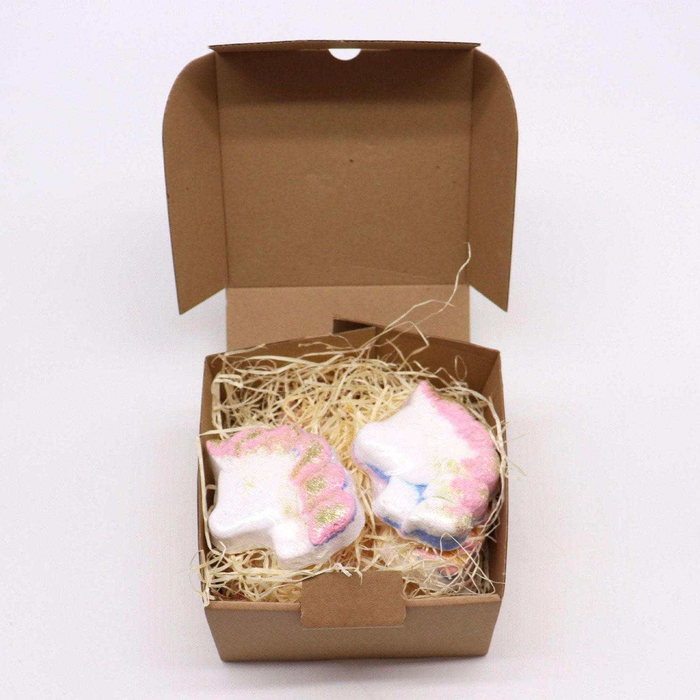Unicorn bathbombs with passion fruit scent in a brown box with straw filler
