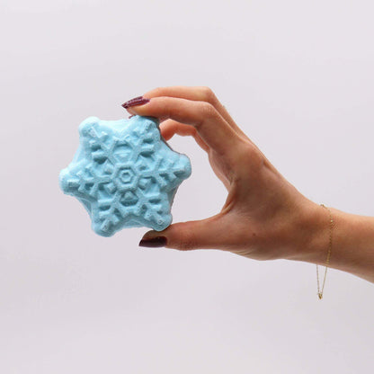 Hand holding blue snowflake bath bomb from Follow the Star Christmas Bath Bomb Gift Pack