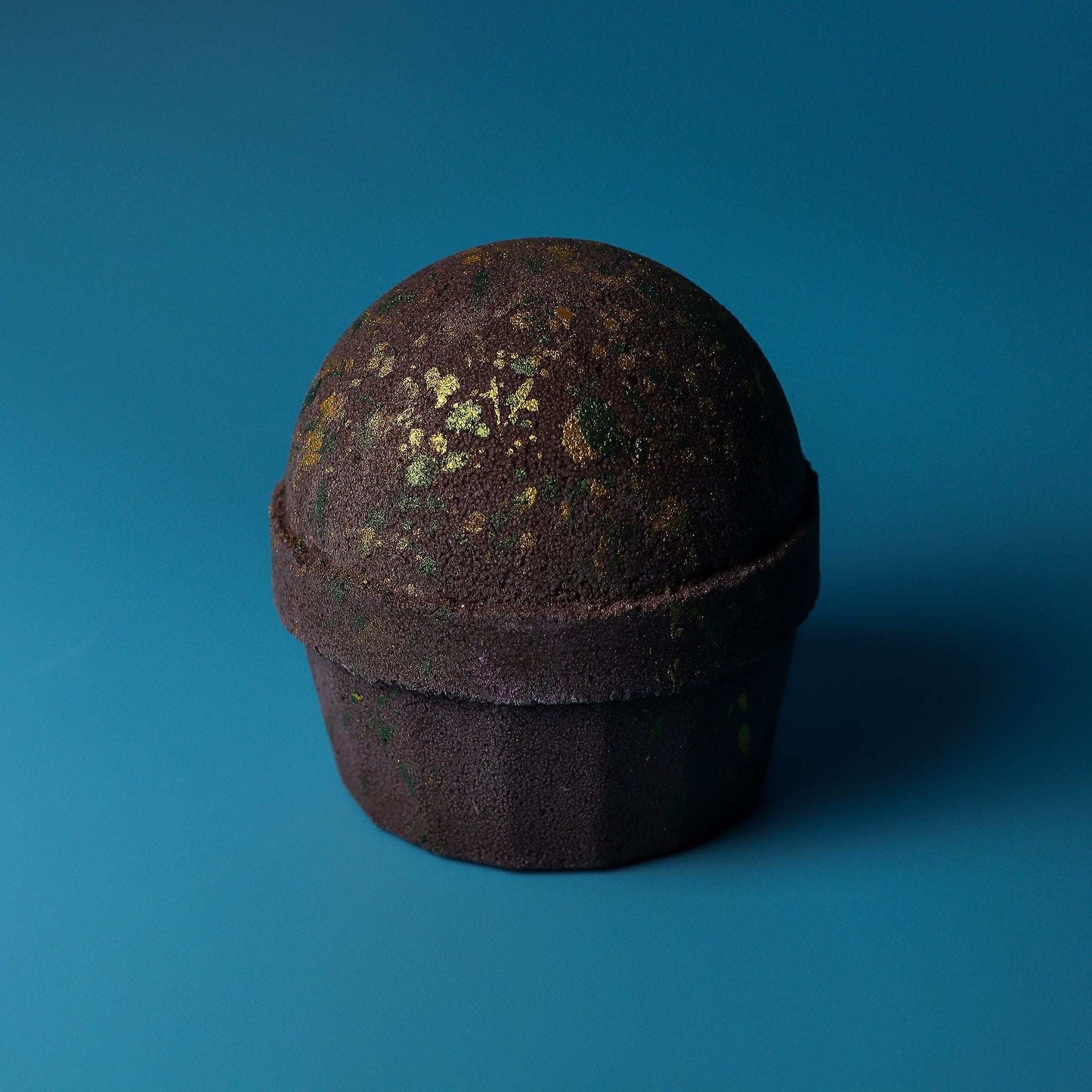 Dubai Bath Bomb Emerald Oudh Truffle with dark chocolate and oriental gourmand fragrance on blue background