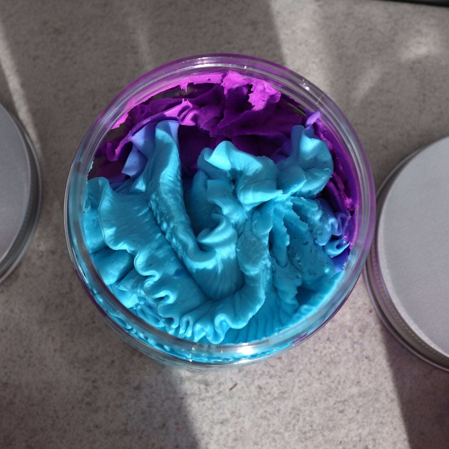 Amethyst Creed Whipped Soap in vibrant purple and blue creamy texture in open jar on gray surface
