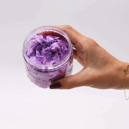 Hand holding jar of Frosted Sugar Plum Whipped Soap with purple whipped texture and glitter shimmer