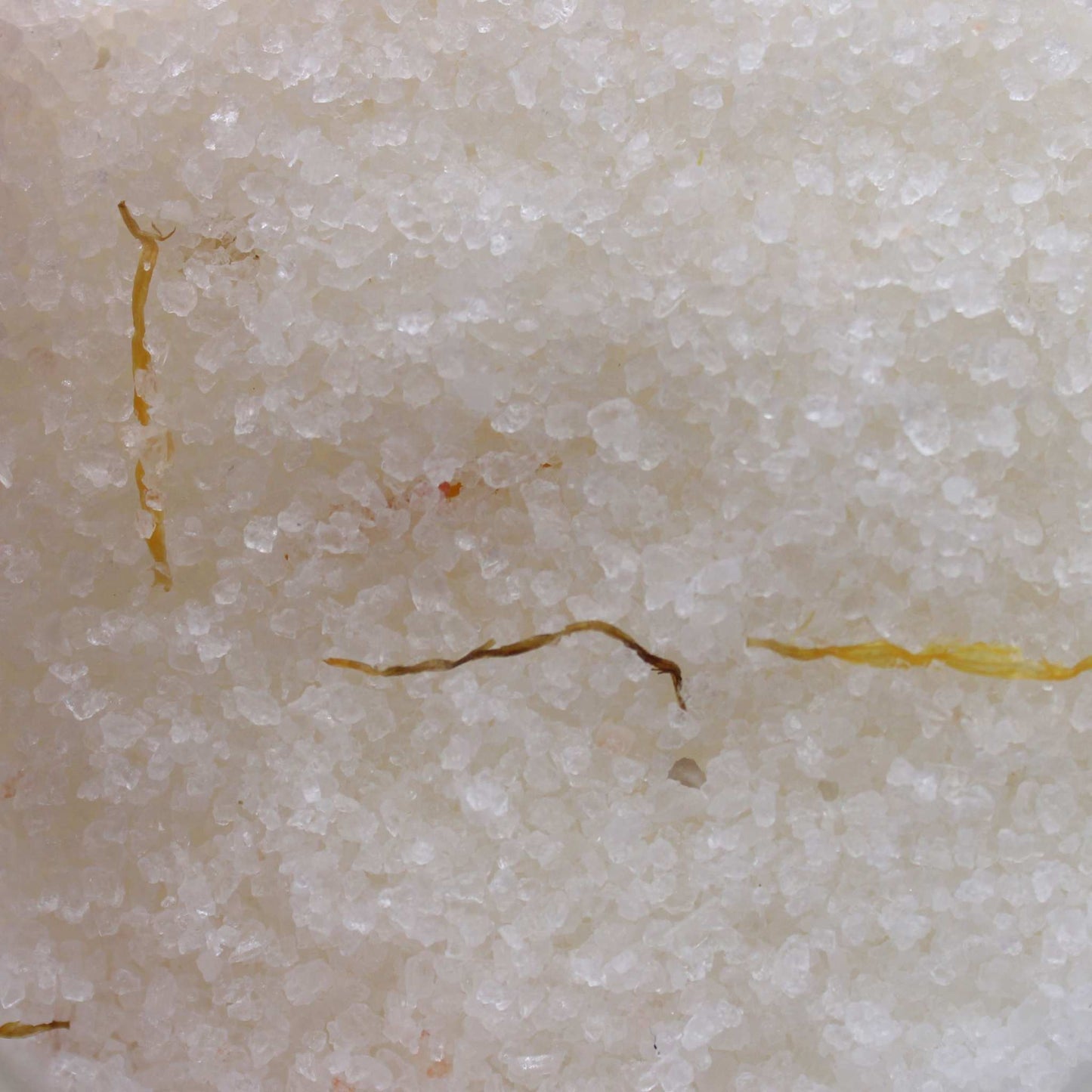 Close-up of mineral-rich Himalayan bath salt with dried marigold flowers infused with essential oils