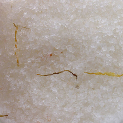 Close-up of mineral-rich Himalayan bath salt with dried marigold flowers infused with essential oils