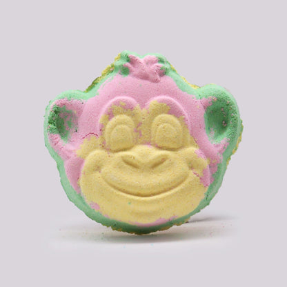 Monkey-shaped bath bomb in pink, green, and yellow colors infused with guava and strawberry fragrance