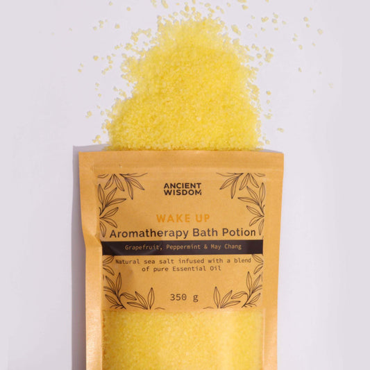 350g Wake Up Aromatherapy Bath Potion with grapefruit, peppermint, and May Chang in kraft bag spilling yellow sea salt crystals