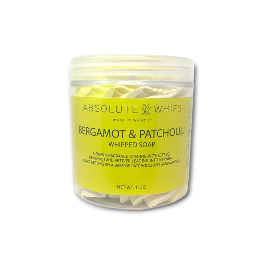Bergamot and Patchouli whipped soap in a clear plastic jar with a yellow label and creamy textured soap inside