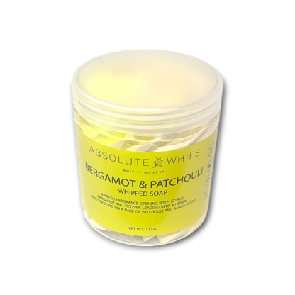 Bergamot and Patchouli whipped soap in translucent plastic jar with pale yellow label and creamy whipped butter texture inside