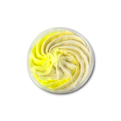 Bergamot and Patchouli whipped soap with a swirled yellow and cream fluffy texture in a round clear container