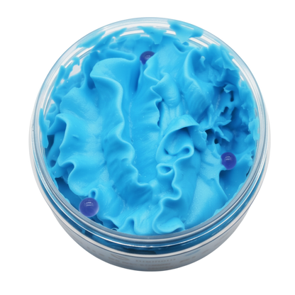 Blueberry Whipped Soap in bright blue fluffy swirls with visible dark blueberry pieces in a clear round container