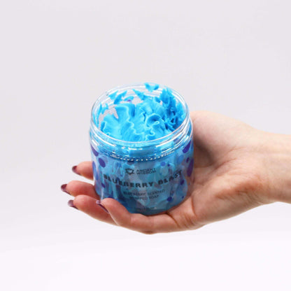 Blueberry Whipped Soap in a clear jar, vibrant blue whipped texture and blueberry-patterned label visible
