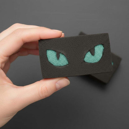 Black Halloween bath bomb with glowing teal cat eyes