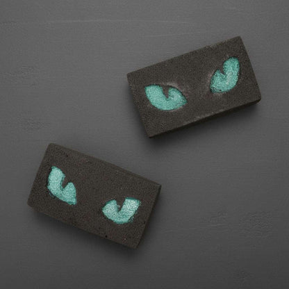 Halloween bath bomb with glowing teal cat eyes