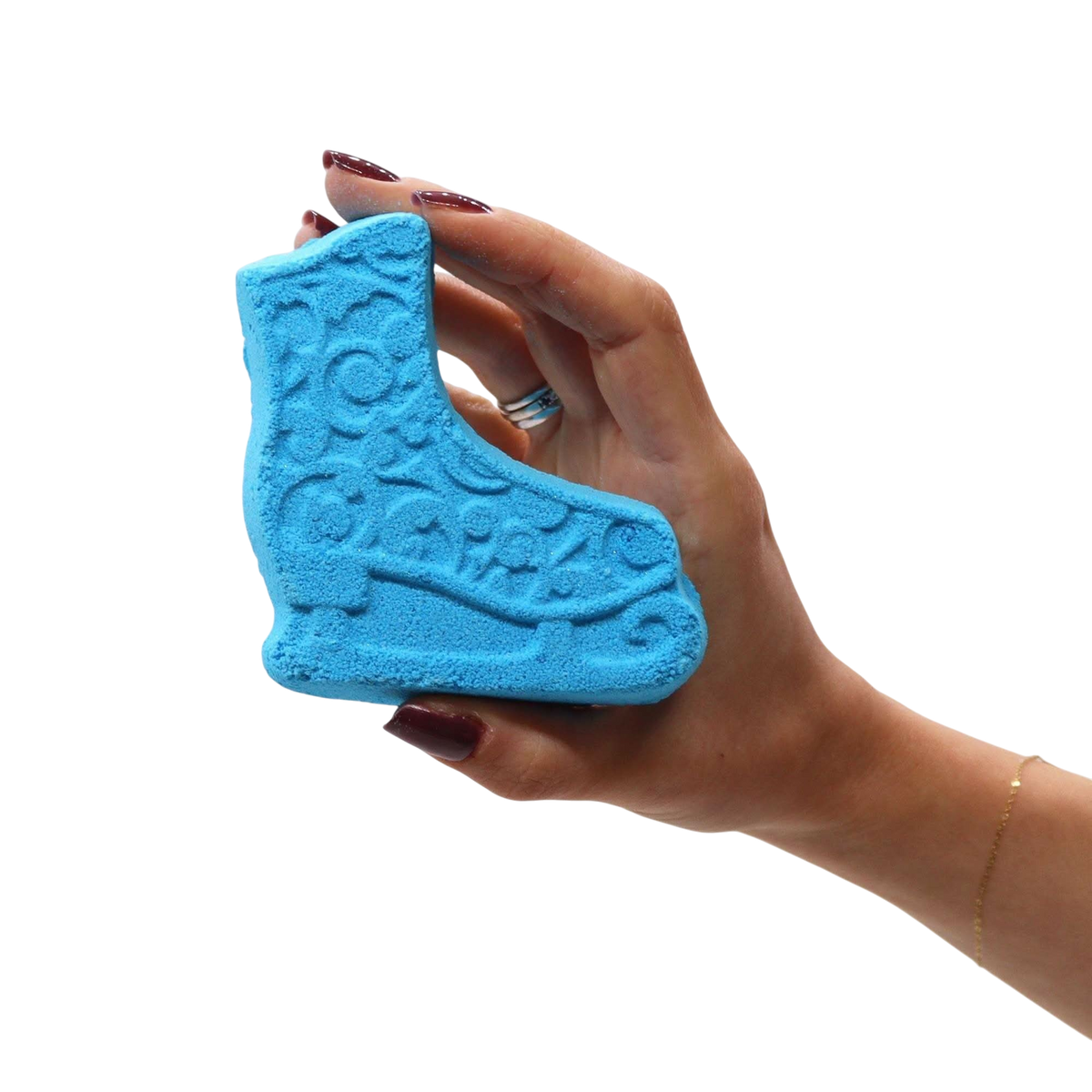 Christmas Fun Bath Bomb Gift Pack featuring a blue bath bomb shaped like an ice skate with embossed details held in a hand