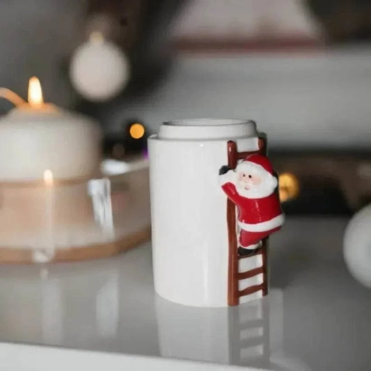 Climbing Santa Wax Burner with a white ceramic vessel, red Santa figure and brown ladder attached to the side