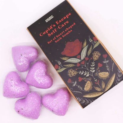 Cupids Escape Self Care heart shaped purple bath bombs set with decorative black box featuring floral design and red text