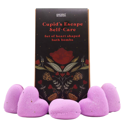 Cupids Escape Self Care set featuring five pink heart-shaped bath bombs with a dark floral-themed box showcasing red and gold accents