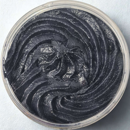 Top view of black citrus sugar body scrub in a clear container showing textured swirl pattern