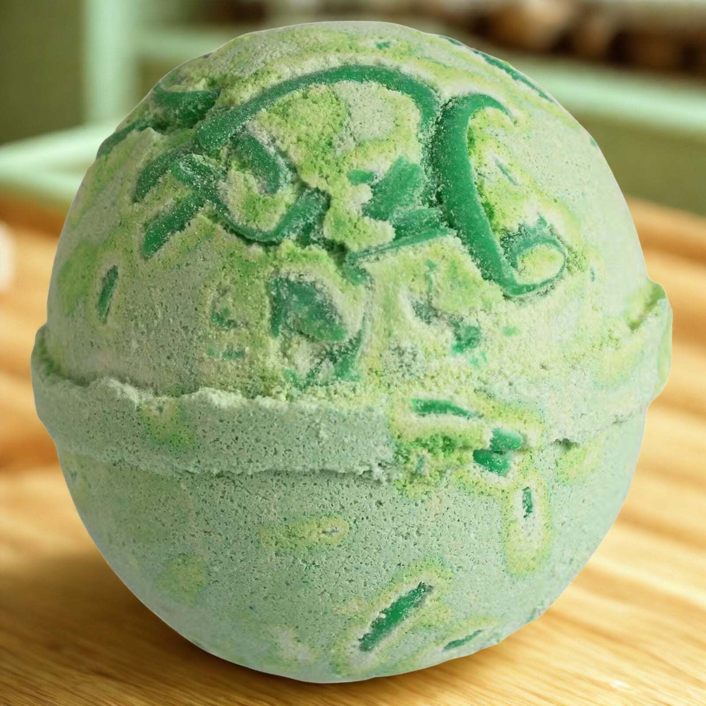 Green and yellow Tropical Paradise Coco Bath Bomb with kiwifruit scent on wooden surface