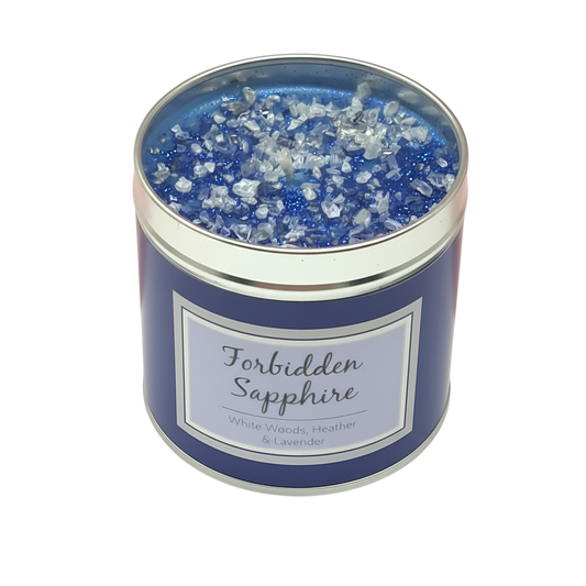 Forbidden Sapphire Scented Candle in a blue tin container with glittery blue and clear crystal-like toppings on the wax surface